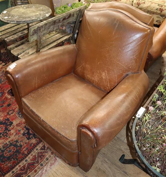 A pair of brown leather club armchairs